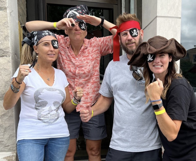 A group of four individuals dressed as pirates and posing.